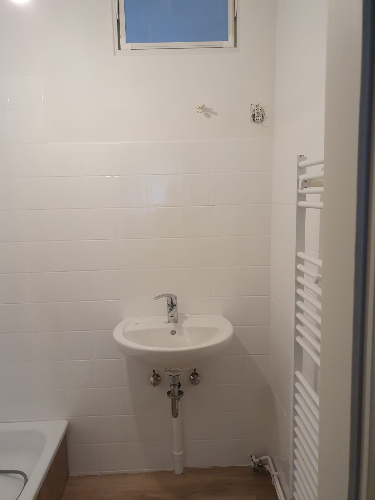 Modernisiertes kleines Badezimmer mit weißen Fliesen und neuem Waschtisch