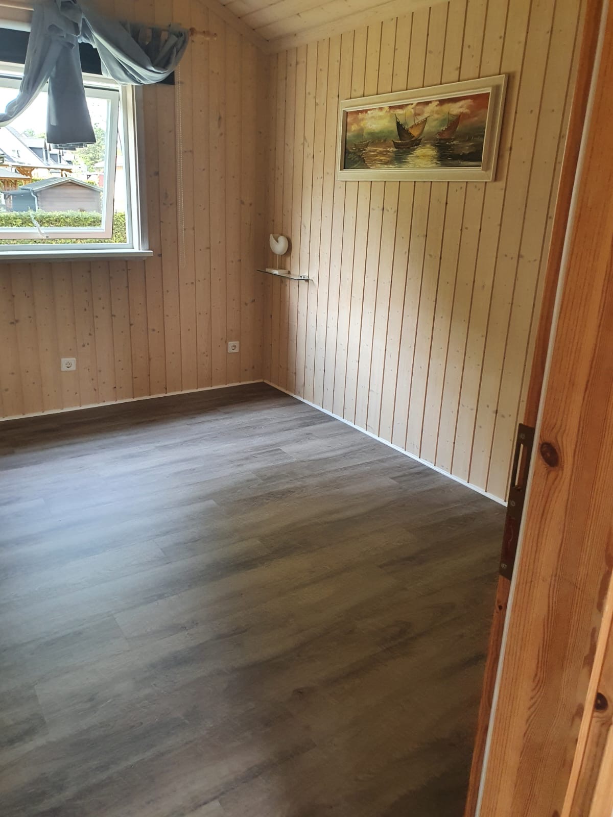 Fertig verlegter grauer Designboden in einem holzverkleideten Raum