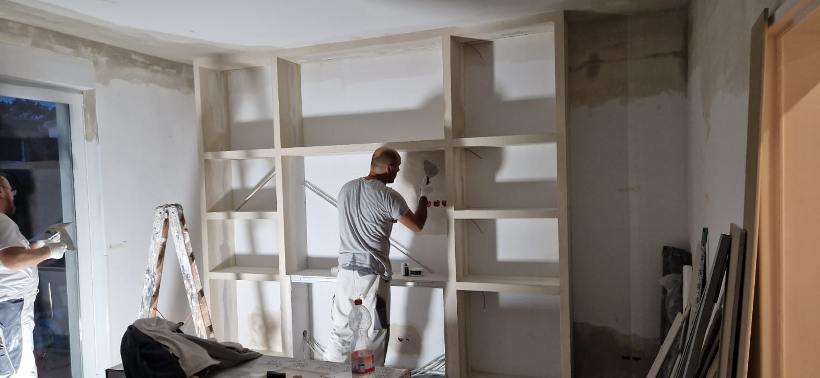 Arbeiten an einer maßgefertigten Wohnwand mit Fächern